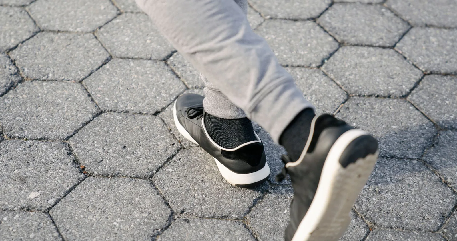 Runner lacing up lightweight sneakers outdoors, in the understated style Allbirds is known for