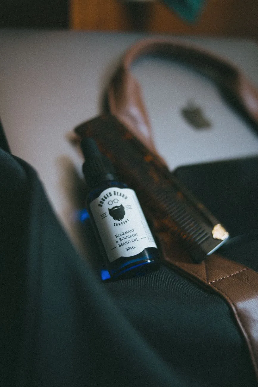 Beard oil bottle and comb styled on leather, in the editorial grooming style Beardbrand is known for