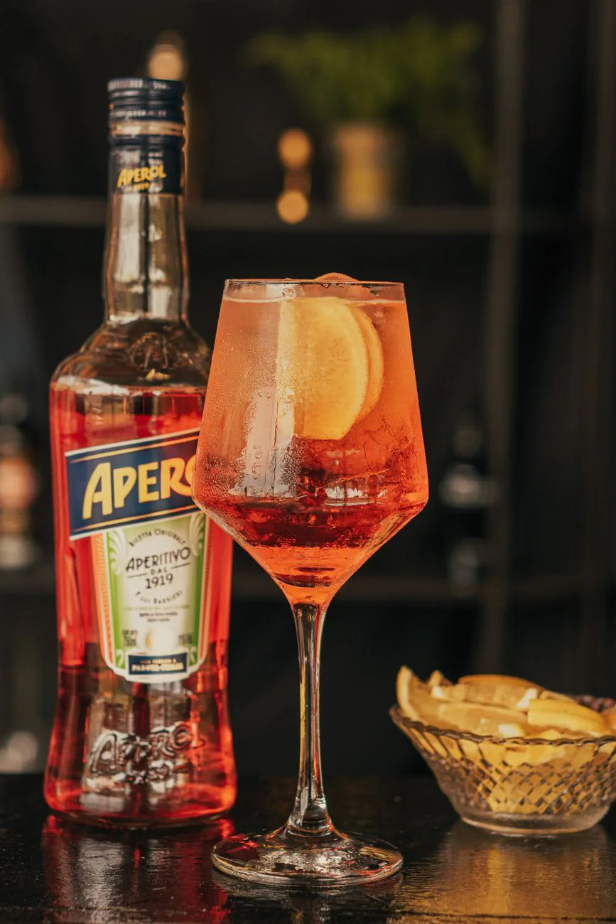 An aperitif serve with orange garnish, in the warm lifestyle style Haus uses