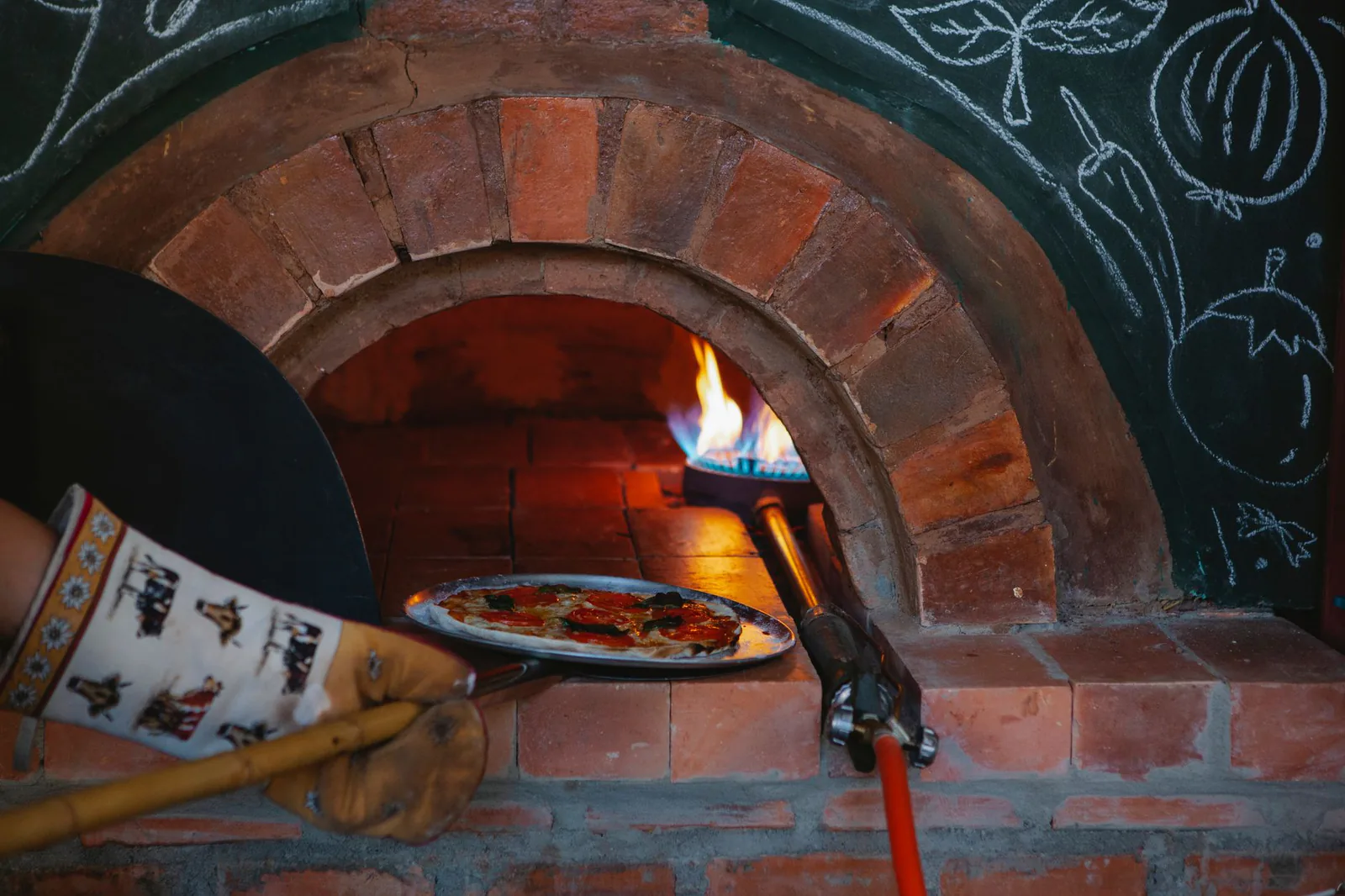 Pizza baking in a wood-fired oven at a cozy pizzeria